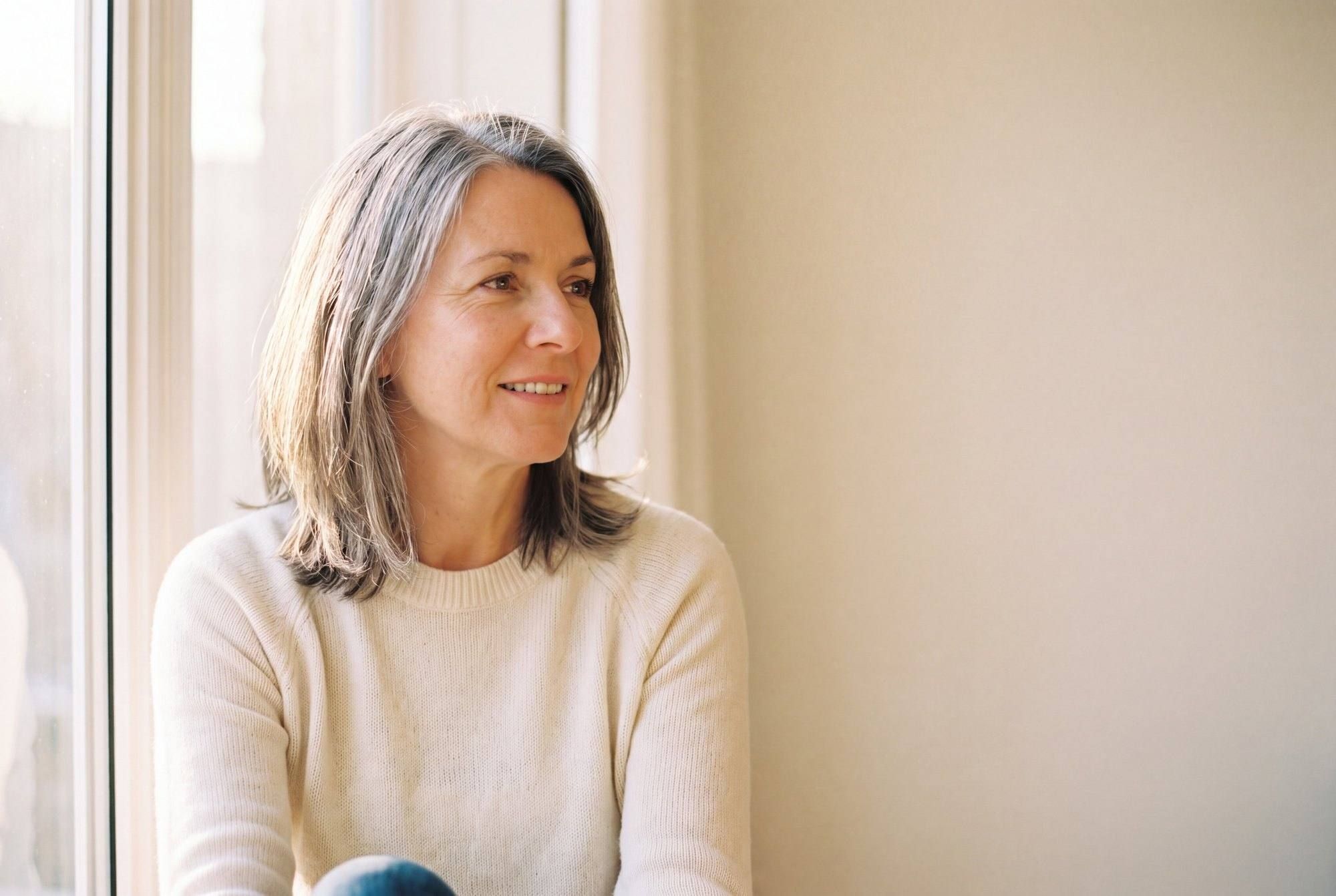 Woman in her 50s seated in a bright, comfortable setting